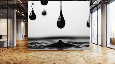 A black water droplet is falling into a body of water Wall mural