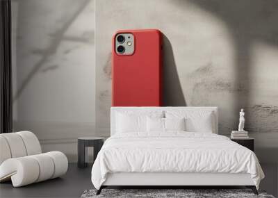 A red cell phone case sits on a white wall Wall mural