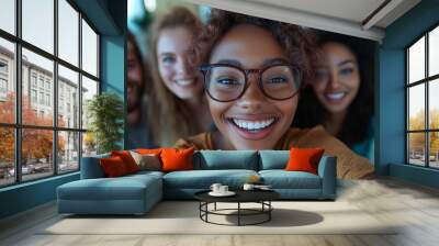 Diverse group of colleagues smiling for a selfie in a modern office, showcasing camaraderie and inclusivity in a casual work environment Wall mural