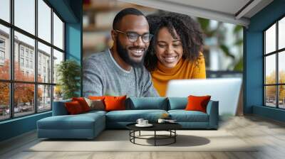 Happy couple smiling in front of a computer screen, enjoying a shared moment together Wall mural