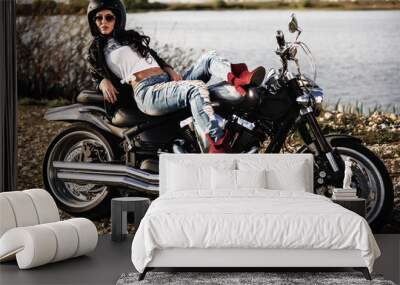 Beautiful brunette woman with a classic motorcycle (cinema bleach bypass effect) Wall mural