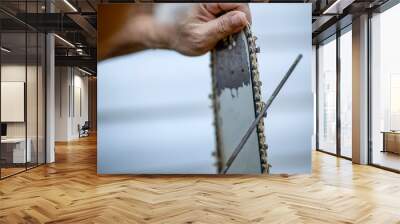 Sharpening a chainsaw Close up on a man sharpening a chainsaw chain with file Wall mural