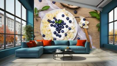 Tasty pasta with fresh organic blueberries and vanilla cream. Sweet dinner on retro wooden table. Wall mural