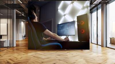 Professional gamer in his expensive studio young man having live stream playing online video game. Cyber sportsman is streaming popular pc computer game for his followers     Wall mural