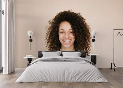 Studio portrait smiling dark skinned female with Afro haircut isolated over brown background   Wall mural