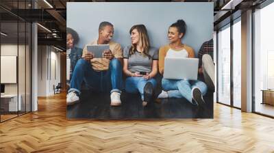 The age of digital citizenship. Studio shot of a group of young people using wireless technology against a gray background. Wall mural