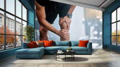 Fitness, gym and mockup, man with knee pain and medical emergency from workout injury at sports studio. Exercise, health and wellness, bodybuilder with hand on leg muscle ache for relief at training. Wall mural