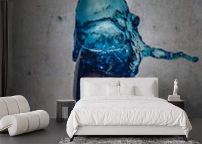 blue mojito cocktail splashing in a wine glass, with a white wooden background. Wall mural