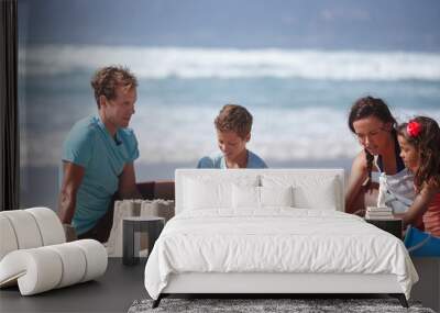 Building sandcastles- one of lifes simple pleasures. Shot of a happy family building sandcastles together at the beach. Wall mural