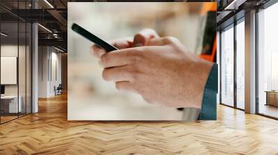 Social media, internet and hands of an architect with a phone for communication, construction website and building app. Construction worker working on a mobile, typing on web and doing search on site Wall mural