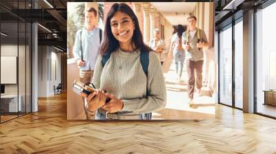 University student, indian woman and portrait at campus outdoor with books of learning, education or knowledge, scholarship and motivation. Happy, smile and young college student, studying or academy Wall mural