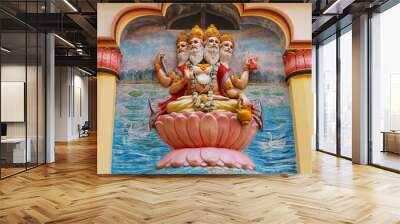 View of wall art of Hindu god Brahma. Brahma, the four-headed lord, sits on a lotus flower. Religious image on the temple in India. Wall mural