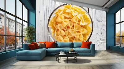 Uncooked farfalle rigate pasta on white wooden background Wall mural