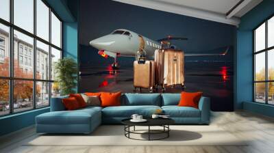 Golden suitcases standing on an airstrip in front of a private jet during night Wall mural