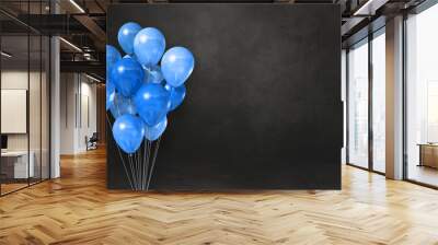 Blue balloons bunch on a black wall background. Horizontal banner. Wall mural