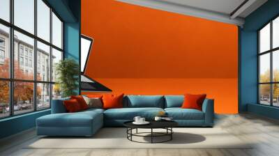 Floating computer laptop isolated on orange. Horizontal banner background Wall mural