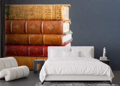 Stack of old books on dark background Wall mural