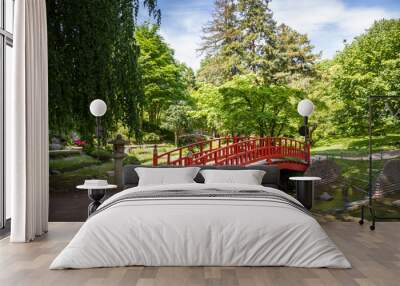 Traditional red wooden bridge on a japanese garden pond Wall mural