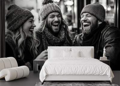 A joyful black and white image of three friends in warm winter attire sharing laughter and coffee outside a bustling city cafe, capturing friendship and happiness. Wall mural