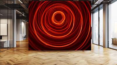 A beautiful, bright light swirl of red color. Futuristic light painting on a black background. Round light circles Wall mural