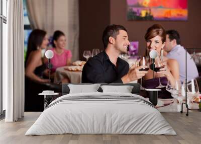 happy couple at restaurant table toasting Wall mural