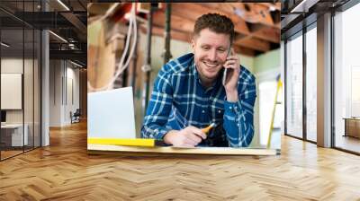 Architect Inside House Being Renovated Working On Plans Using Laptop And Talking On Cellphone Wall mural