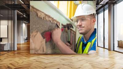 Construction Worker With Chisel Removing Plaster From Wall In Renovated House Wall mural