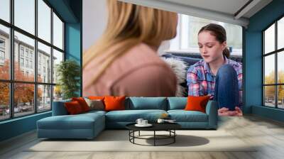 Mother Having Serious Conversation With Worried Young Daughter At Home Wall mural