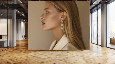 jewelry lookbook, side profile caucasian model with long blonde hair, her shoulders are relaxed, her ears are adorned with eye-catching earrings, cream background. Wall mural