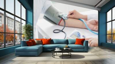 The doctor measures blood pressure to the patient Wall mural