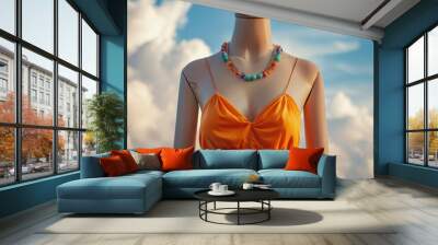 A mannequin wears a vibrant orange dress paired with a colorful necklace, showcasing a lively and bold fashion statement. Wall mural