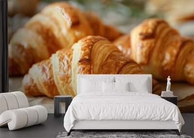 Close-up of golden, flaky croissants on a rustic wooden table, capturing their delicious texture. Wall mural