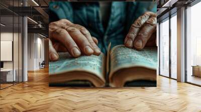 Elderly hands reading a Braille book, symbolizing learning, wisdom, and the power of tactile communication for the visually impaired. Wall mural