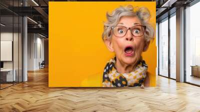 Surprised senior woman with glasses on red background. Free copy space for text. Wall mural