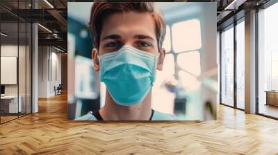 Young male dentist wearing a face mask, posing confidently in a dental clinic. Free copy space for banner. Wall mural