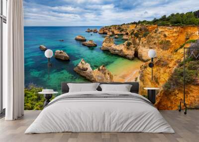 View of stunning beach with golden color rocks in Alvor town , Algarve, Portugal. View of cliff rocks on Alvor beach, Algarve region, Portugal. Wall mural