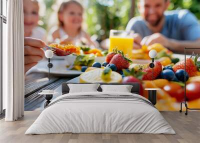 Family sharing meal outdoors at summer picnic Wall mural