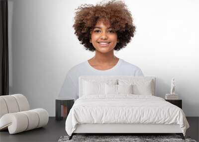 African american smiling teenage girl with afro hairstyle holding phone with both hands, chatting with friend, using social media app Wall mural