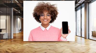 African female teen showing smart phone with blank screen with copy space, isolated on gray background Wall mural