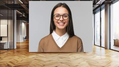 Beautiful smiling female college teacher wearing trendy glasses, isolated on gray background Wall mural