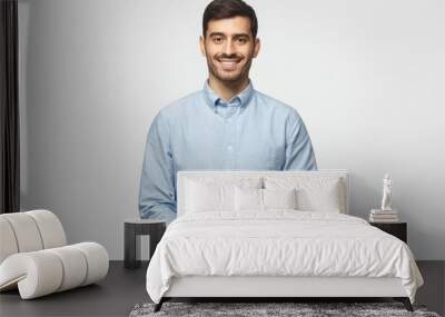 Handsome business man isolated on gray background, standing and showing positive smile to camera, looking confident Wall mural