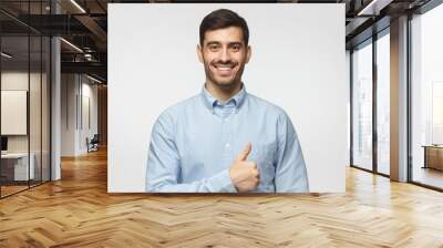 handsome male showing thumb up approving and advising service or product, isolated on grey backgroun Wall mural