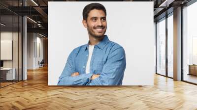 handsome young man isolated on gray background, dressed in casual blue shirt, having turned aside as Wall mural