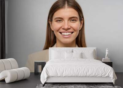 Headshot portrait of smiling woman teacher looking at camera on gray background Wall mural