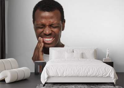 horizontal shot of african american man pictured against gray background feeling severe toothache he Wall mural