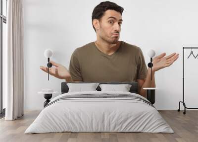 i don't know. young man isolated on grey background being at a loss, showing helpless gesture with a Wall mural