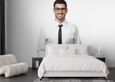 Indoor portrait of handsome European businessman pictured isolated on white background dressed in white formal shirt and black tie standing in front of camera, feeling positive, confident and calm Wall mural