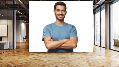 indoor portrait of young european man standing in blue t-shirt with crossed arms, smiling and lookin Wall mural