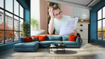 Indoor shot of young European Caucasian girl looking at financia Wall mural