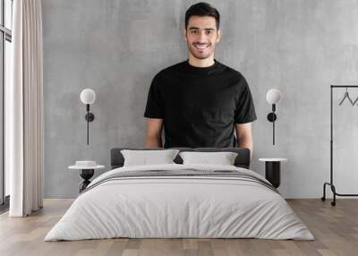 Mock up of young man body in empty black t-shirt isolated on textured gray wall background Wall mural